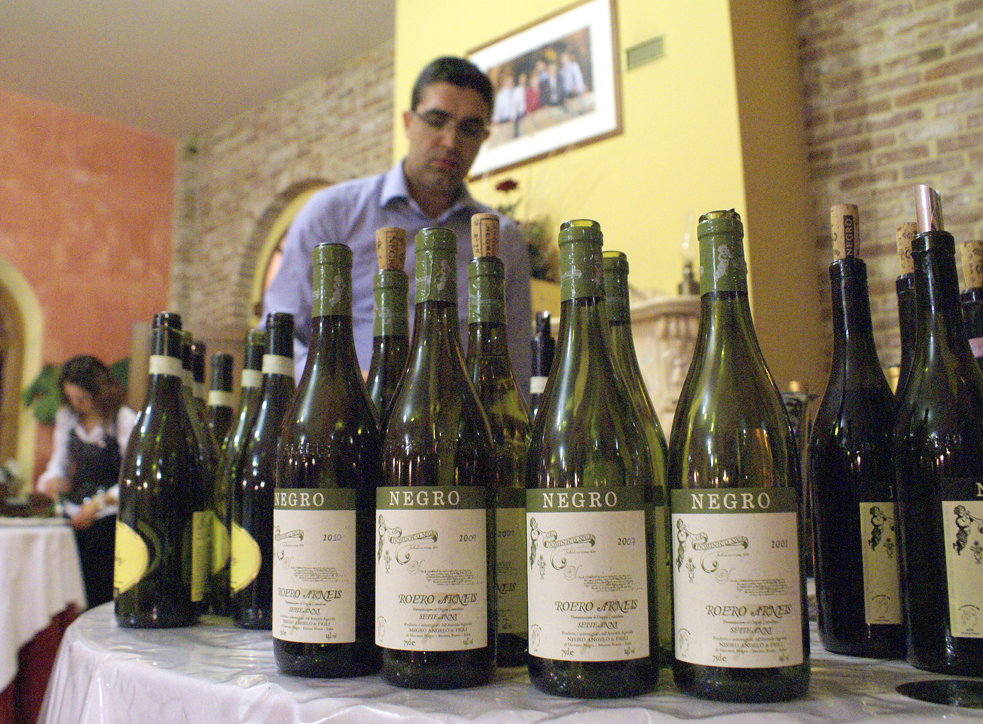 The historical vertical of Negro Arneis; in the background is winemaker Angelo Negro.